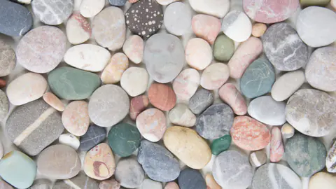 Close view of mixed river rock showing color and size variation