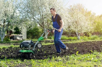 man tilling soil to build a flower bed