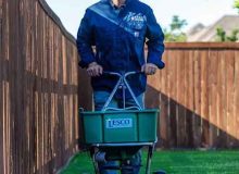 ryno-pushing-cart-lawn-fertilization-weed-prevention-in-flower-mound-e1731026041974.jpg